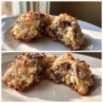 A close-up of a low calorie almond joy cookie broken in half, showing melted chocolate chips and coconut texture.