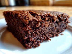 Close-up of a rich, dark slice of Cottage Cheese Microwave Brownie on a white plate.