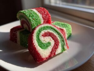 Close-up of three colorful pinwheel cookies showing red, white, and green spirals coated in sparkling sugar.
