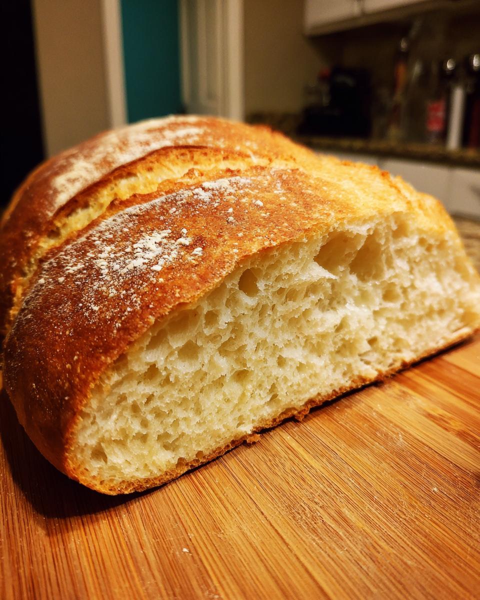 Close-up of a freshly baked french bread loaf, showing the golden crust and airy crumb texture.