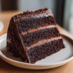 A decadent slice of dark chocolate layered capricorn cake with chocolate frosting.
