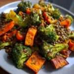 Close-up of a vibrant veggie lentil salad featuring roasted sweet potato chunks, bright green broccoli, and brown lentils.