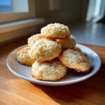 A stack of golden, crumbly 3-ingredient butter cookies piled high on a small white plate.
