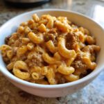 Close-up of creamy, cheesy homemade hamburger helper with elbow macaroni and ground beef in a white bowl.
