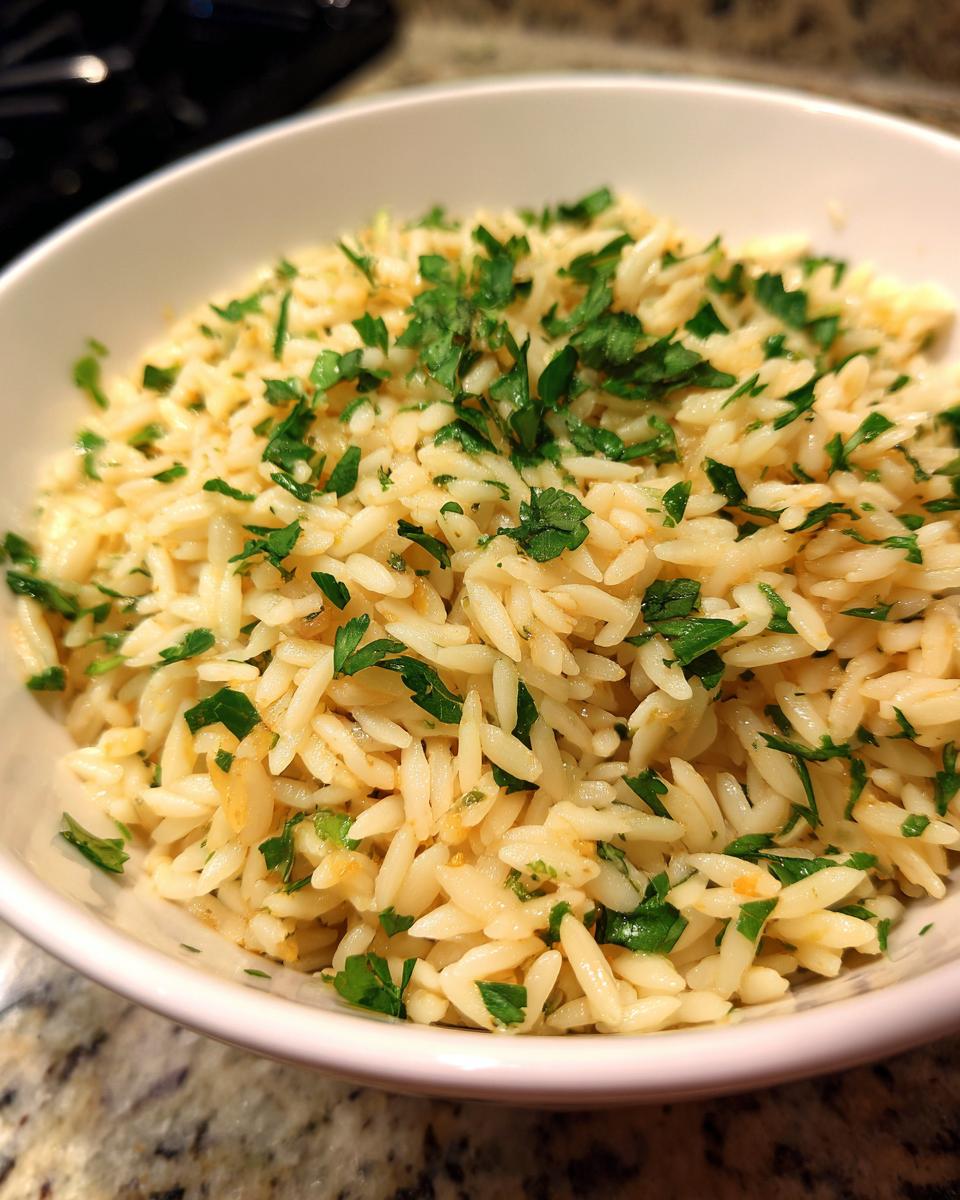 Close-up of fluffy rice pilaf served in a white bowl and garnished generously with chopped fresh parsley.