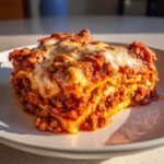 A close-up, appetizing serving of lazy lasagna layered with rich meat sauce and melted mozzarella cheese.