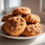 A close-up stack of soft coffee cake cookies generously coated in cinnamon sugar topping.