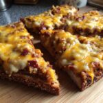 Close-up of several slices of the hanky panky recipe topped with melted cheddar and Monterey Jack cheese on toast.