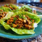 Close-up of delicious chicken lettuce wraps filled with savory ground chicken and topped with fresh green onions.