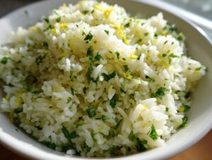 Close-up of fluffy white rice mixed with chopped cilantro and bright yellow lime zest, serving as cilantro lime rice.