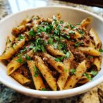 Close-up of creamy beef pasta made with penne, topped generously with fresh parsley.