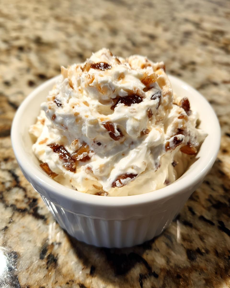 A small white ramekin filled with creamy onion dip topped with caramelized onions, sitting on a granite countertop.