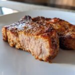Close-up of a perfectly cooked, juicy air fryer pork chops, showing a seasoned, browned exterior and tender interior.