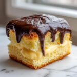 A square slice of boston cream pie featuring yellow cake, thick vanilla custard filling, and dripping chocolate ganache topping.