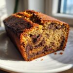 Close-up of a freshly baked chocolate chip banana bread recipe loaf showing melted chocolate chips inside.