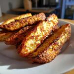 Close-up of several golden-brown, seasoned potato wedges showing a very crunchy exterior.