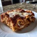 A hearty serving of easy crockpot ravioli lasagna topped with rich tomato sauce and melted mozzarella cheese.