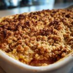 Close-up of a freshly baked rhubarb crisp with a deeply golden, crunchy oat topping.