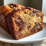 Close-up of a moist slice of peanut butter chocolate chip banana bread showing melted chocolate chips.