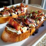 Two slices of maple bacon goat cheese crostini topped with crumbled bacon, goat cheese, and a balsamic glaze.
