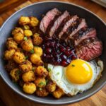 A bowl featuring sliced rib eyes cherries roast, fried okra, a sunny-side-up egg, and cherry sauce.